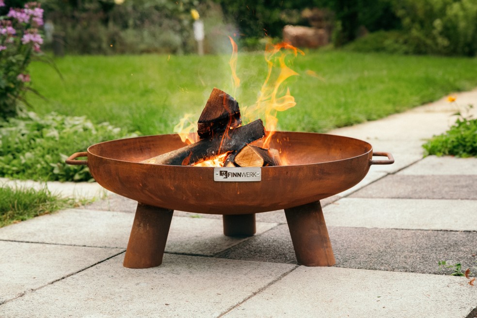 Feuerschale HARRI 60 Rostoptik im grünen Garten mit Feuer von FINNWERK