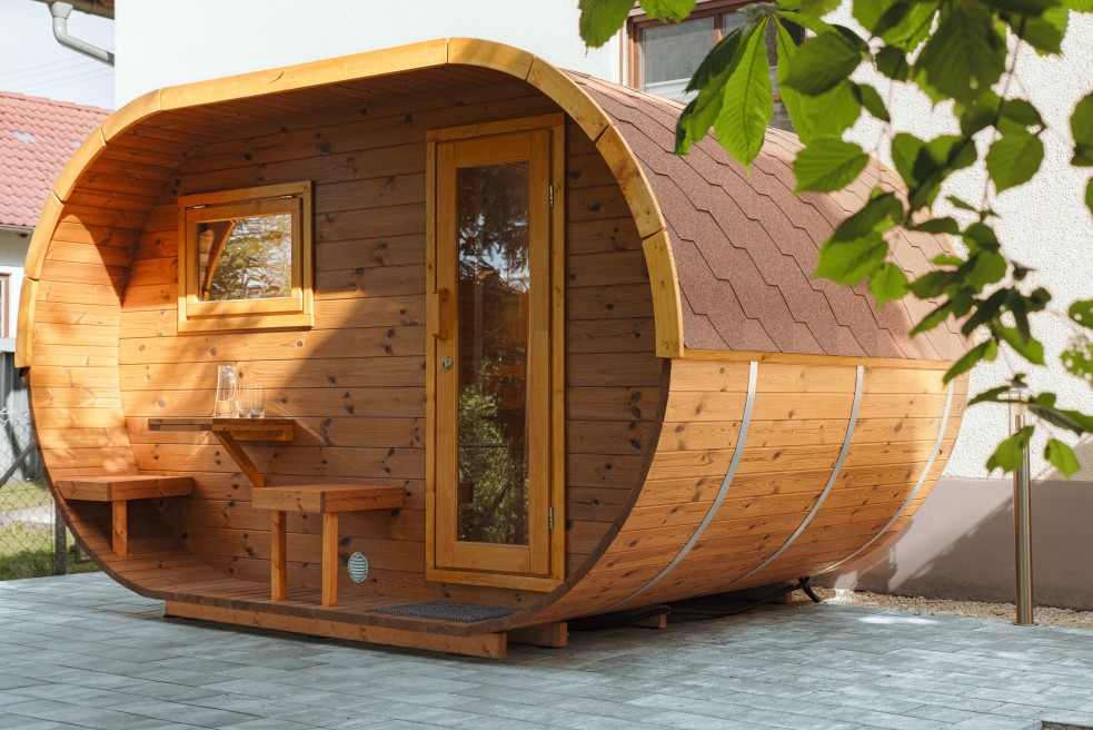 Gartenaufnahme des Saunafass Oval Deluxe von Finnwerk