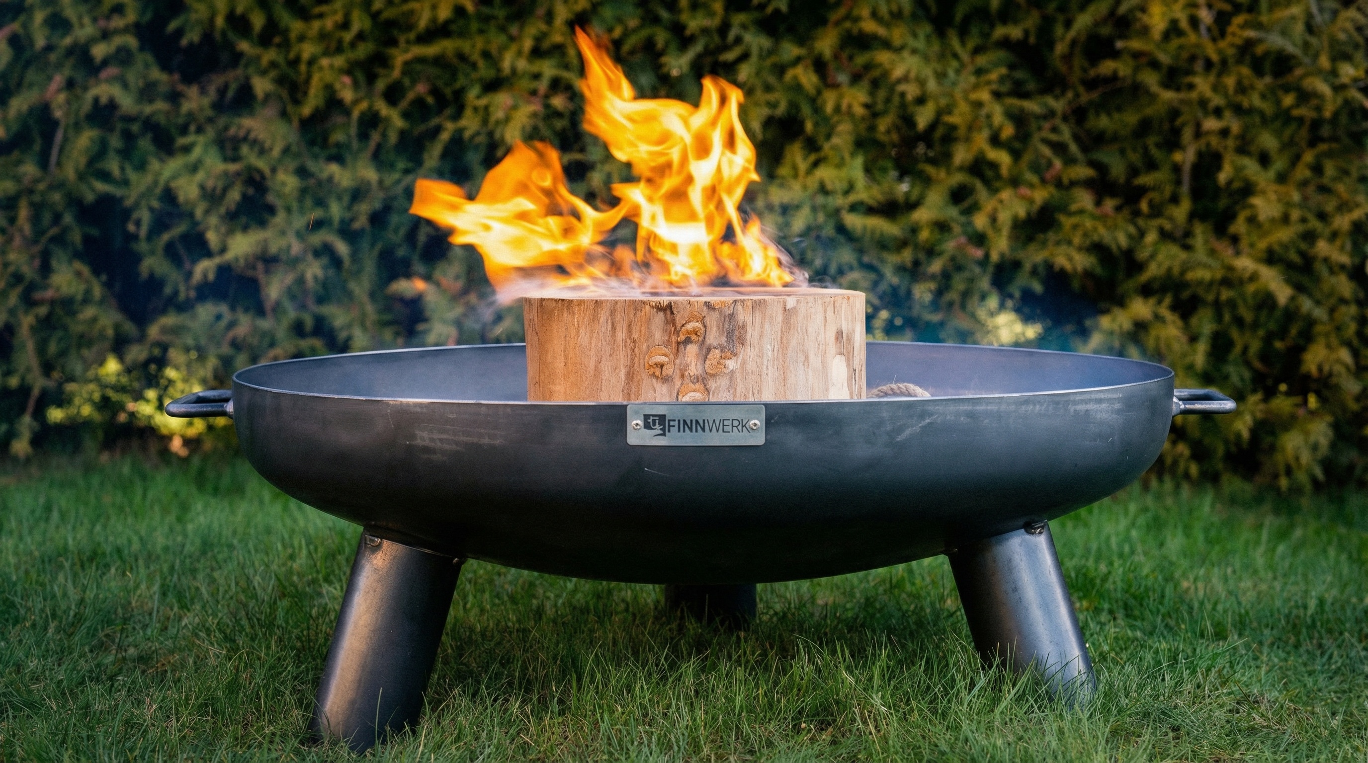 Brennendes Finnwerk Schwedenfeuer in stimmungsvoller Abendatmosphäre im Garten
